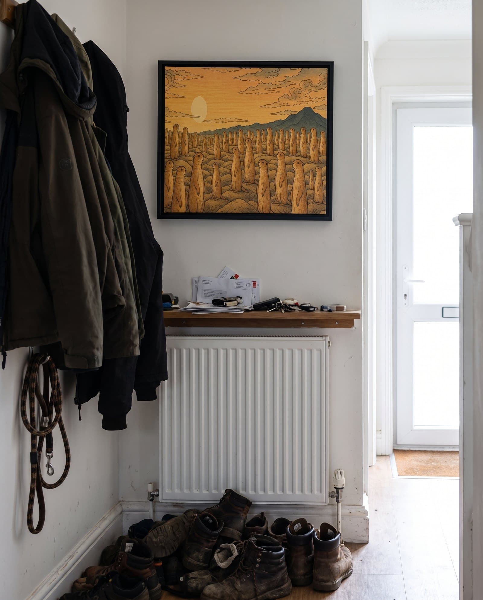 A painted animal portrait on canvas hanging in a hallway above a radiator and a pile of shoes